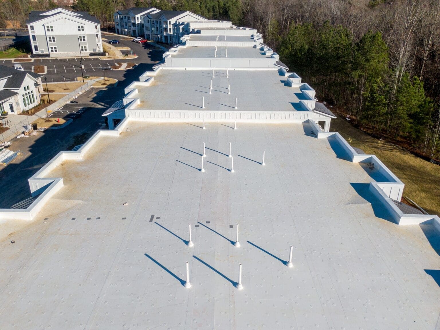 Aerial view of a newly installed white single-ply membrane roof covering a large commercial building