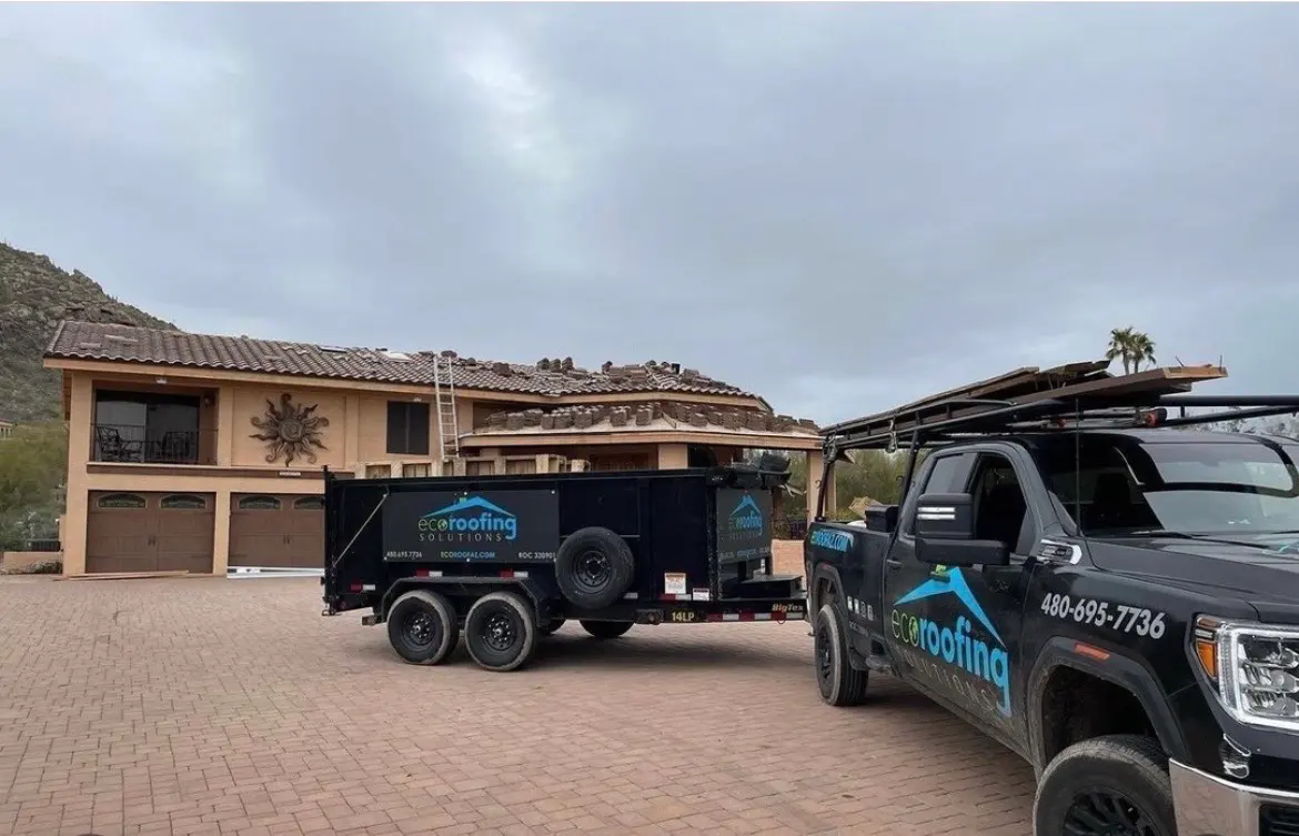 Eco Roofing Solutions branded truck and dump trailer parked outside an Arizona home during a tile roof tear-off