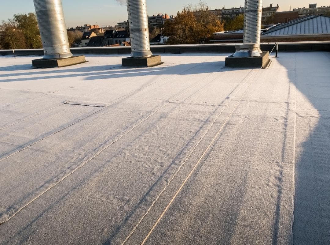 Close-up of a commercial building flat roof membrane with insulated vent stacks